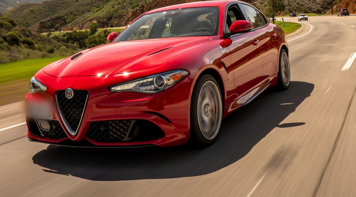 Punainen Alfa Romeo Giulia -mallinen ajoneuvo tiellä